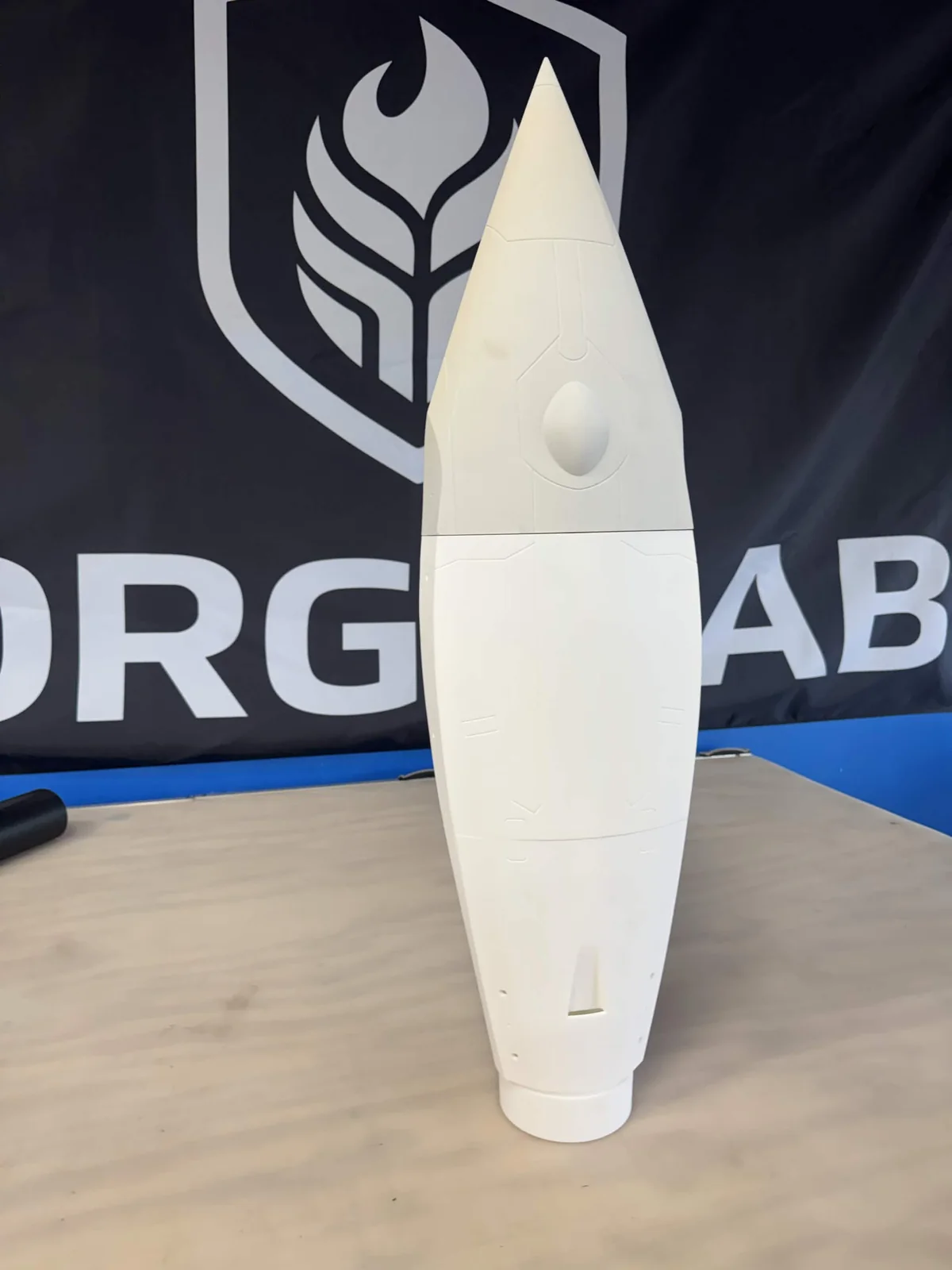 Assembled white FARSIDE rocket hardware standing on a workbench
